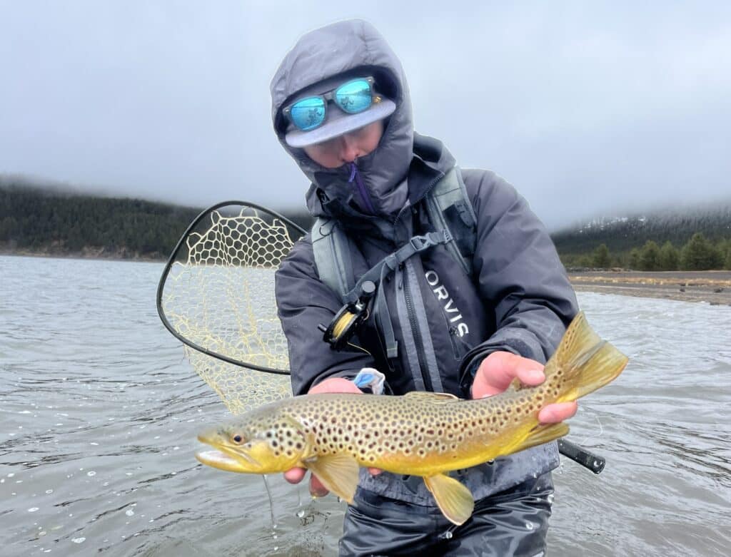 Bundled up angler holding a brown trout